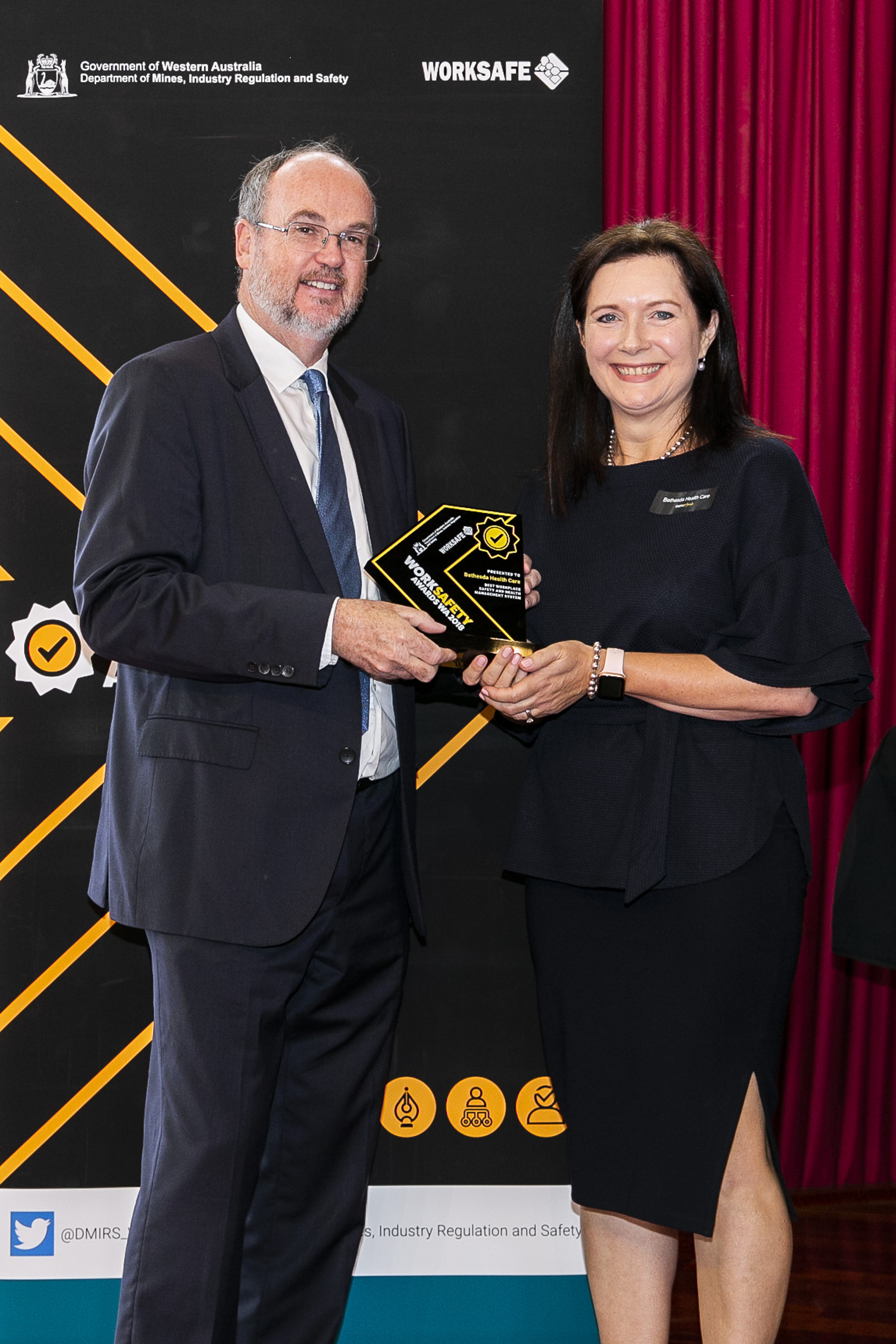 Minister Bill Johnston presenting Melody Miles, Bethesda Health Care with the winning trophy for 'Best workplace safety and health management system'